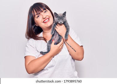 Young Beautiful Plus Size Woman Smilling Happy And Confident. Standing With Smile On Face Holding Adorable Cat Over Isolated White Background