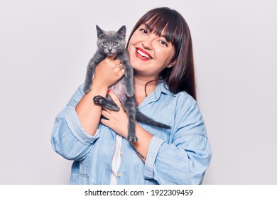 Young Beautiful Plus Size Woman Smilling Happy And Confident. Standing With Smile On Face Holding Adorable Cat Over Isolated White Background