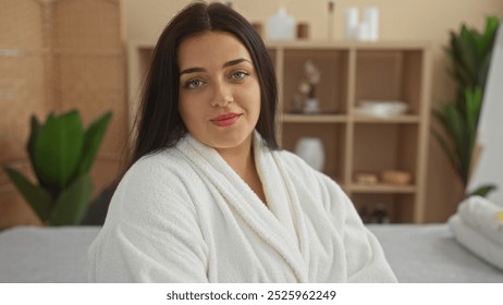 Young, beautiful, plus-size woman relaxing in a spa room while wearing a white bathrobe, exuding calmness and wellness in a serene indoor setting. - Powered by Shutterstock