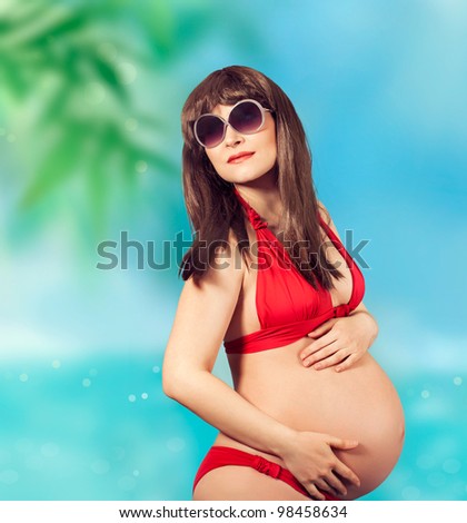 Young beautiful pregnant woman on tropical beach
