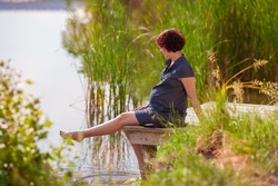 Young Beautiful Pregnant Woman Relaxing At The Lake