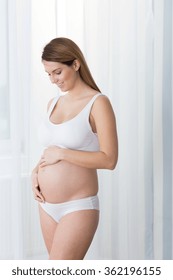 Young Beautiful Pregnant Woman In White Underwear