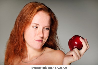 young beautiful red hair girl holds an apple