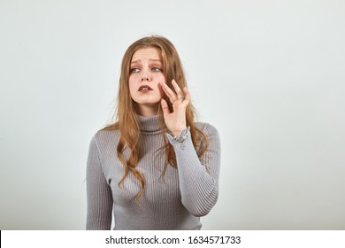 A Young Beautiful Red Haired Woman In Gray Sweater With Sad Look Says Goodbye Waving Her Hand And Sadness In Eyes