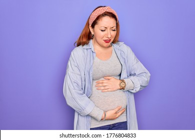 Young Beautiful Redhead Pregnant Woman Expecting Baby Over Isolated Purple Background With Hand On Stomach Because Indigestion, Painful Illness Feeling Unwell. Ache Concept.