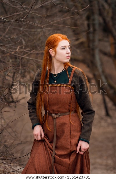 Young beautiful redhead viking woman in brown woolen historical viking