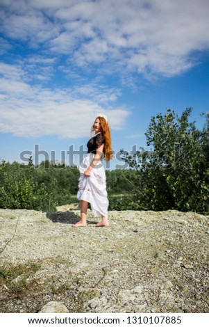Young beautiful redhead woman on the stone