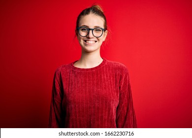 Young Beautiful Redhead Woman Wearing Casual Sweater Over Isolated Red Background With A Happy And Cool Smile On Face. Lucky Person.