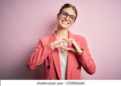 Young beautiful redhead woman wearing jacket and glasses over isolated pink background smiling in love doing heart symbol shape with hands. Romantic concept. - Powered by Shutterstock