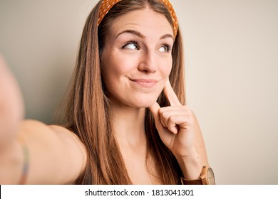 Young Beautiful Redhead Woman Wearing Diadem Make Selfie By The Camera Serious Face Thinking About Question, Very Confused Idea