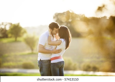 Young beautiful romantic couple in backlit composition