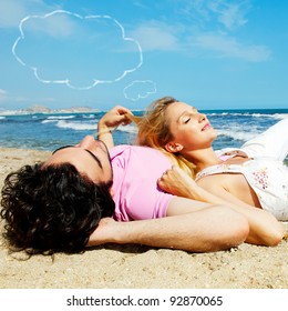 Young Beautiful Romantic Couple Relaxing On Beach At Sunny Day. Blank Cloud Balloon Overhead