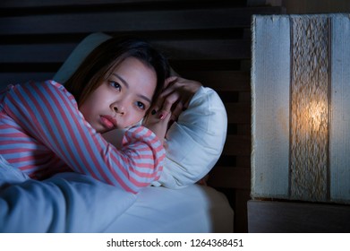 Young Beautiful Sad And Depressed Asian Chinese Girl Lying On Bed Late Night Awake Looking Thoughtful Suffering Insomnia Sleeping Disorder Feeling Tired And Worried In Woman Depression Concept
