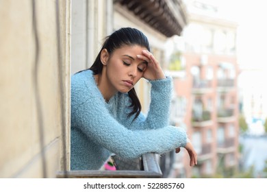 young beautiful sad and desperate hispanic woman suffering depression looking thoughtful and frustrated at apartment balcony looking depressed at the street  - Shutterstock ID 522885760