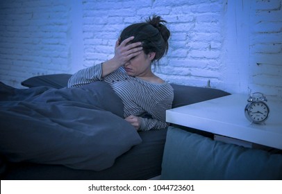 young beautiful sad and worried latin woman suffering insomnia and sleeping disorder problem unable to sleep late at night lying on bed awake feeling stressed and frustrated - Shutterstock ID 1044723601