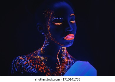 young and beautiful sensual woman of african appearance in fluorescent paint makeup, posing. luminescence paint, body art, neon lights. isolated