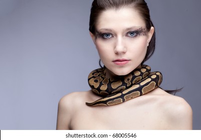 Young, beautiful, sensual woman with snake around her neck; a lot of copyspace available