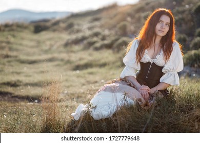 Young Beautiful Sexy Redhead Girl In 18th Century Dress. Outdoor Portrait. Summer Photo