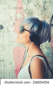 young beautiful short blue hair hipster woman with headphones music in the city - Shutterstock ID 236054356