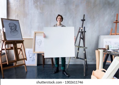 Young beautiful smiling artist teacher student woman girl boy in modern art workshop studio surrounded by black white sketch painting big easel tools hold huge art canvas for new artistic masterpiece - Powered by Shutterstock