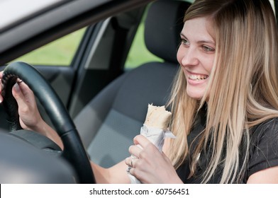 Young Beautiful Smiling Woman Driving Car And Eating Fast Food - Portrait Through Side Window