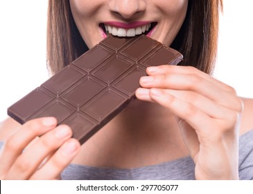 Young Beautiful Smiling Woman Eating Bar Of  Dark Chocolate. Studio Shot. Close-up.