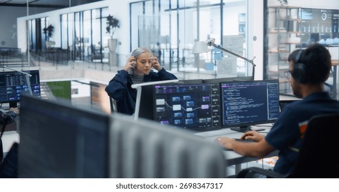 Young Beautiful Software Developer Working on Computer in a Technological Laboratory Environment with Male Colleagues. IT Programming Department Researching and Developing Commercial Internet Products