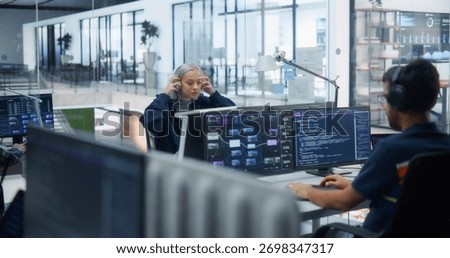 Young Beautiful Software Developer Working on Computer in a Technological Laboratory Environment with Male Colleagues. IT Programming Department Researching and Developing Commercial Internet Products