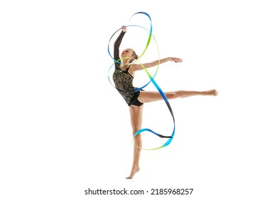 Young beautiful sportive girl, female rhythmic gymnast training with colorful ribbons isolated over white studio background. Concept of action, motion, sport life, competition. Copyspace for ad