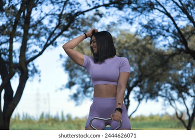 Young, beautiful and sporty woman, wearing sports clothes, playing fun and happy on a seesaw in a park. Concept sport, fitness, fashion, gymnastics.