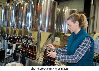 young beautiful standing among brewery stainless equipment - Powered by Shutterstock