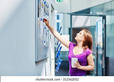 Young Beautiful Student At College Or University Using Notice Board