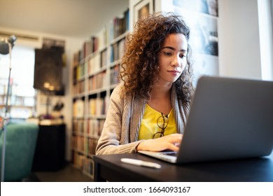 Young beautiful student girl working, learning in college library - Shutterstock ID 1664093167