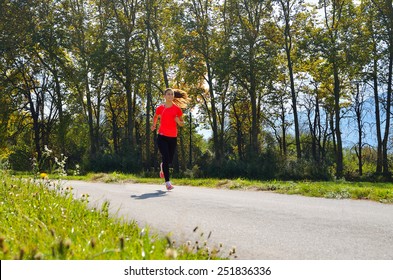 young, beautiful successful fitness woman running in the park, a beautiful sunny day