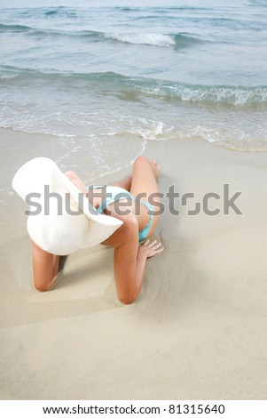 Young beautiful tanned woman in bikini by the sea