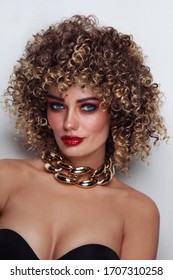 Young beautiful tanned woman with curly afro hair and fancy disco makeup