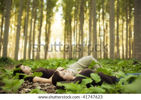 Young beautiful thoughtful girls laying on the ground. Focus on the closest one.