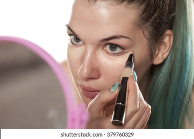 young beautiful woman applied concealer under her eyes