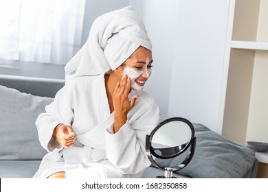 Young Beautiful Woman Applying Homemade Facial Mask I At Home.Skin Care, Beauty Treatments. So Beautiful. Close-up Of Girl With Beauty Mask On Her Face Looking In Mirror.