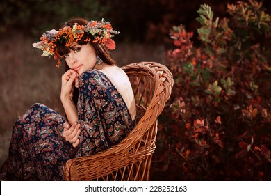 Young beautiful woman in autumn wreath on head