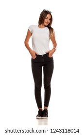Young Beautiful Woman In Black Tight Jeans Posing On White Background
