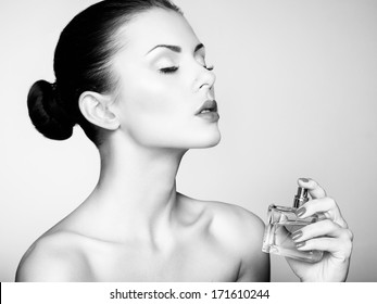 Young beautiful woman with bottle of perfume. Perfect Makeup. Fashion photo