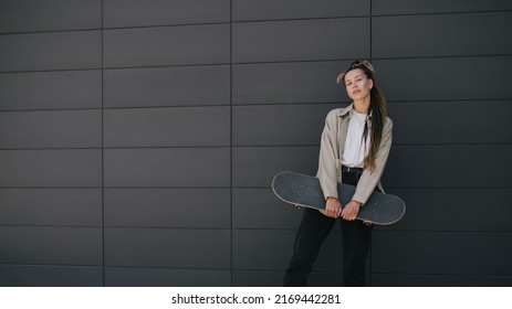 Young beautiful woman with braids style hair wearing casual clothes standing with skateboard on city street. - Powered by Shutterstock