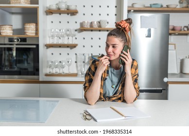 Young Beautiful Woman From A Catering Company Stands In The Kitchen And Calls The Client In Charge Of Planning The Wedding About The Amount And Type Of Food Needed For The Celebration