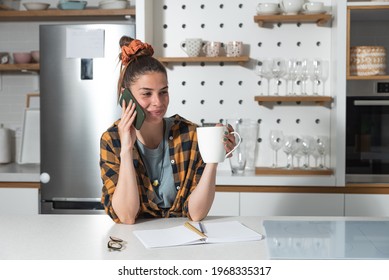 Young Beautiful Woman From A Catering Company Stands In The Kitchen And Calls The Client In Charge Of Planning The Wedding About The Amount And Type Of Food Needed For The Celebration