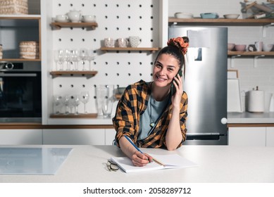 Young Beautiful Woman From A Catering Company Stands In The Kitchen And Calls The Client In Charge Of Planning The Wedding About The Amount And Type Of Food Needed For The Celebration