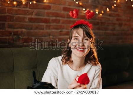 Young beautiful woman celebrating valentine day wearing heart shape funny decoration and cute white dress