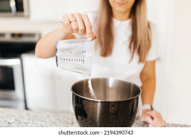 A Young Beautiful Woman Cooks In A Bright Kitchen. Cooking Macaroons. A Cute Girlp Repares Dough For Cakes, Hands And Ingrident Closeup. Cooking Macaroons. Cookie Baking