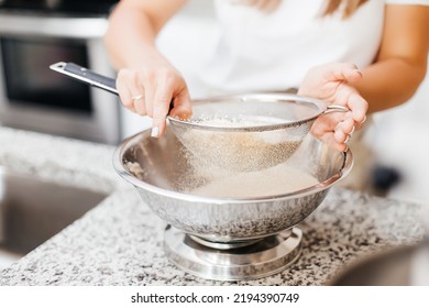 A Young Beautiful Woman Cooks In A Bright Kitchen. Cooking Macaroons. A Cute Girlp Repares Dough For Cakes, Hands And Ingrident Closeup. Cooking Macaroons. Cookie Baking