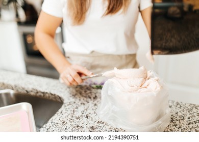 A Young Beautiful Woman Cooks In A Bright Kitchen. Cooking Macaroons. A Cute Girlp Repares Dough For Cakes, Hands And Ingrident Closeup. Cooking Macaroons. Cookie Baking